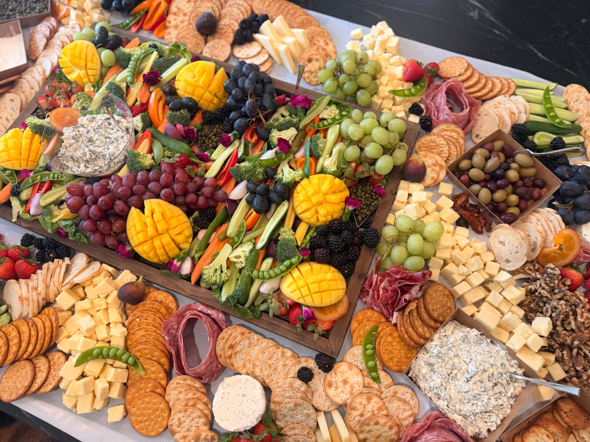 Grazing boards with mango flowers, fresh fruit, cheeses and crackers