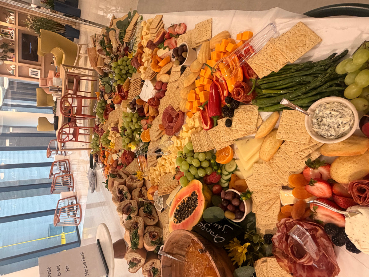 Overhead view of a styled grazing table with fruit, cheese and charcuterie