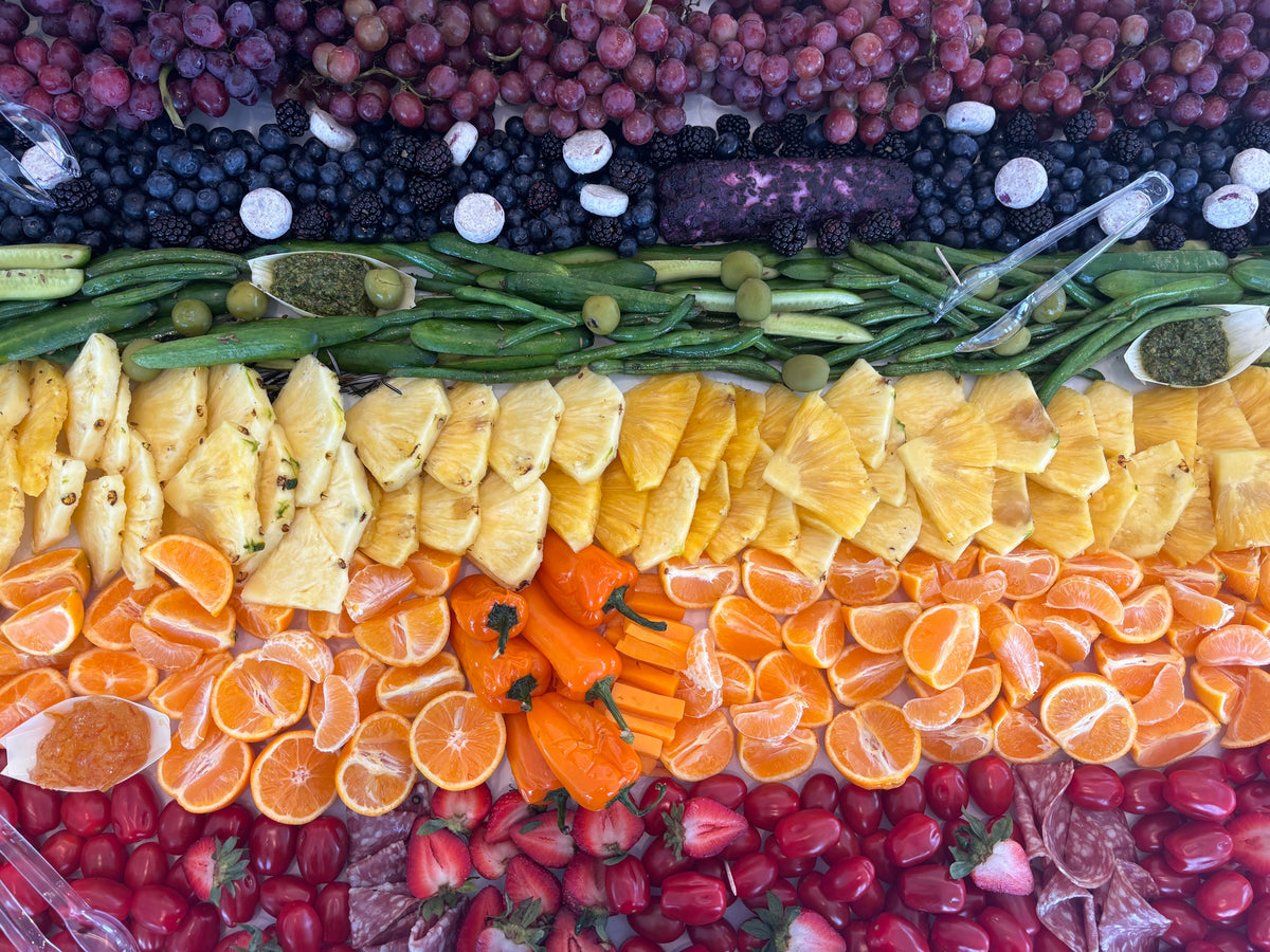 Rainbow rows of berries, citrus and vegetables on a grazing table